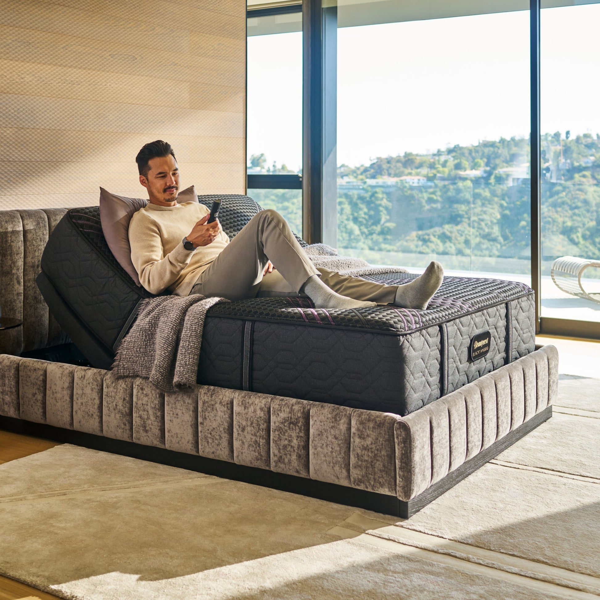 Man sitting on BeautyRest Medium Apex Top Hybrid mattress sitting on an adjustable base || series: Series Two || feel: Medium Apex Top
