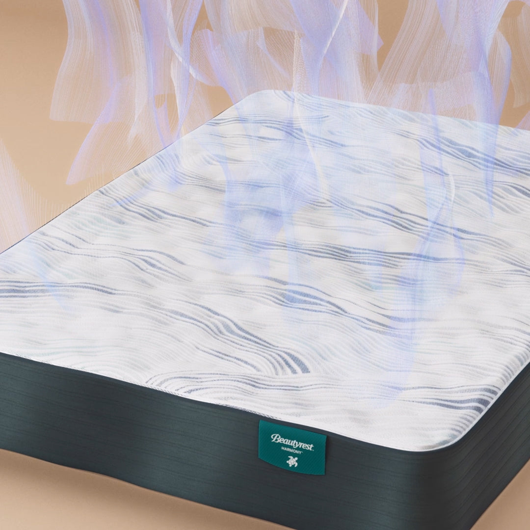 A Beautyrest Harmony mattress with a white and blue wavy patterned surface, shown with a visual effect of cool air rising, highlighting its cooling technology.