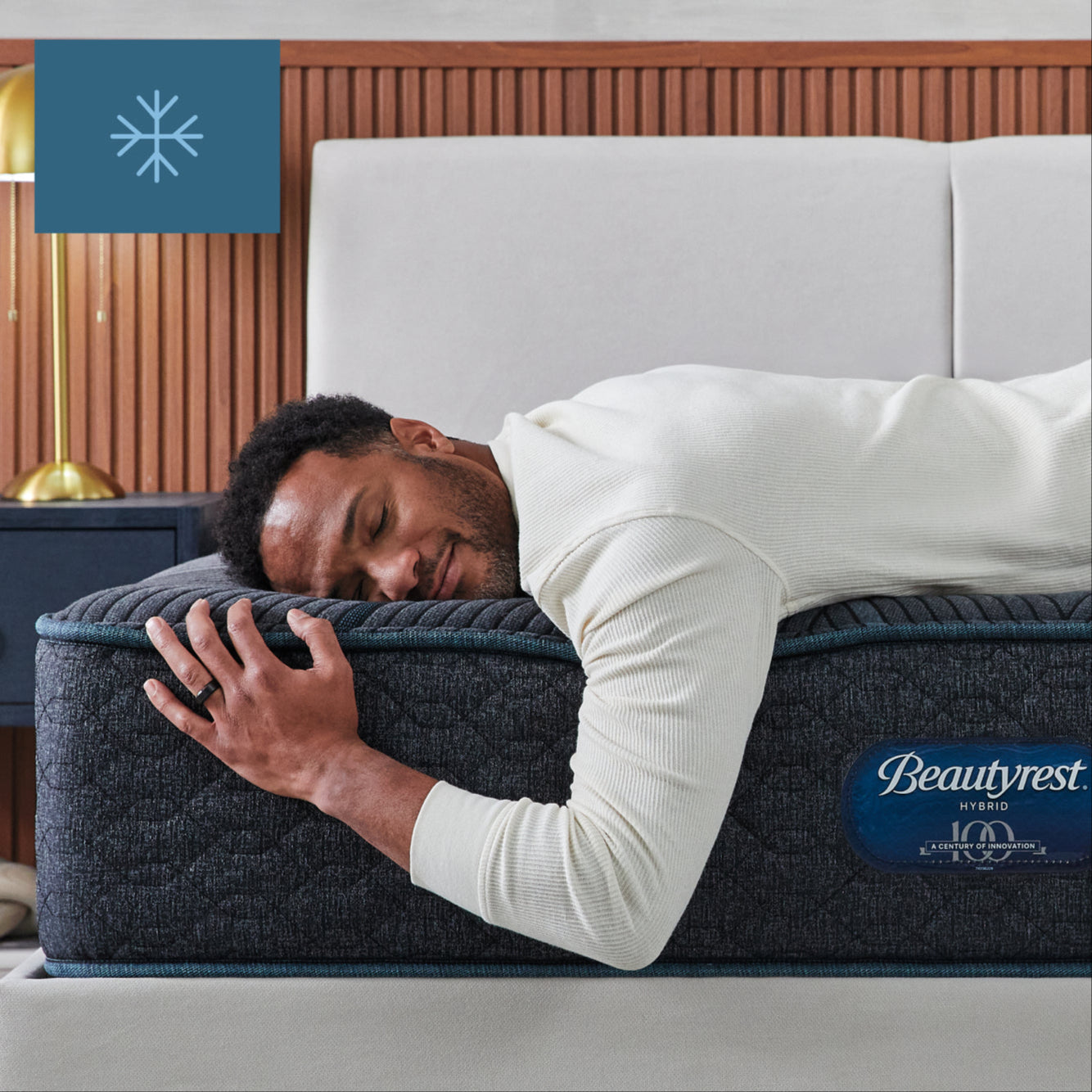 Man laying on his stomach asleep on top of a Beautyrest Hybrid mattress