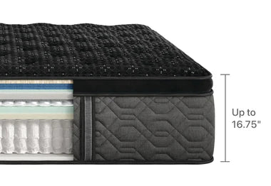 Cross-section of a high-end mattress with a black quilted top featuring subtle embellishments, multiple comfort layers, and pocketed coils, measuring up to 16.75 inches in height.