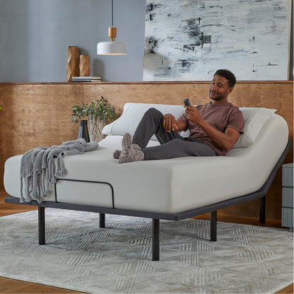 Man sitting in a Baselogic Silver Adjustable Base with a white mattress on top of it. || level: Silver