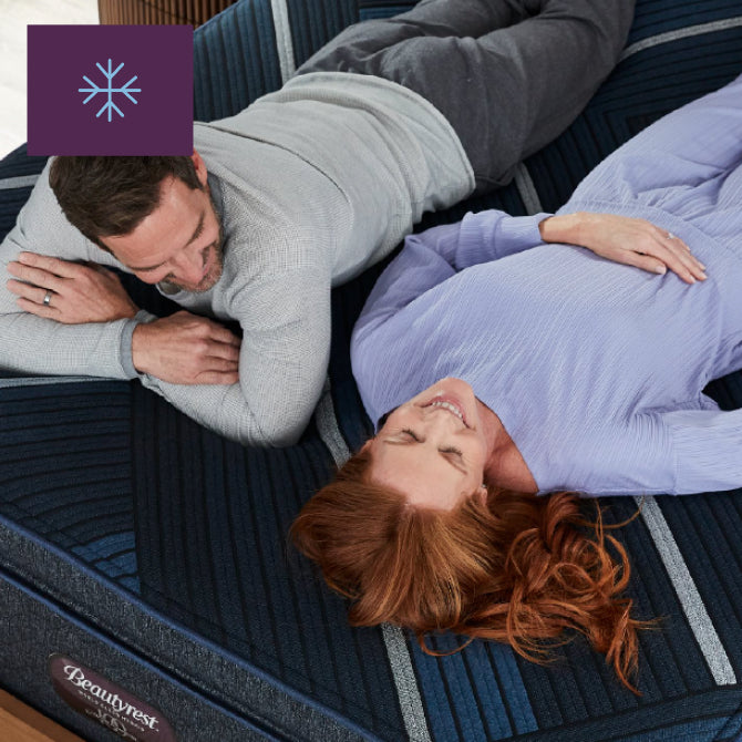 Man and woman laying on top of a Beautyrest World Class Quilted Hybrid mattress side by side