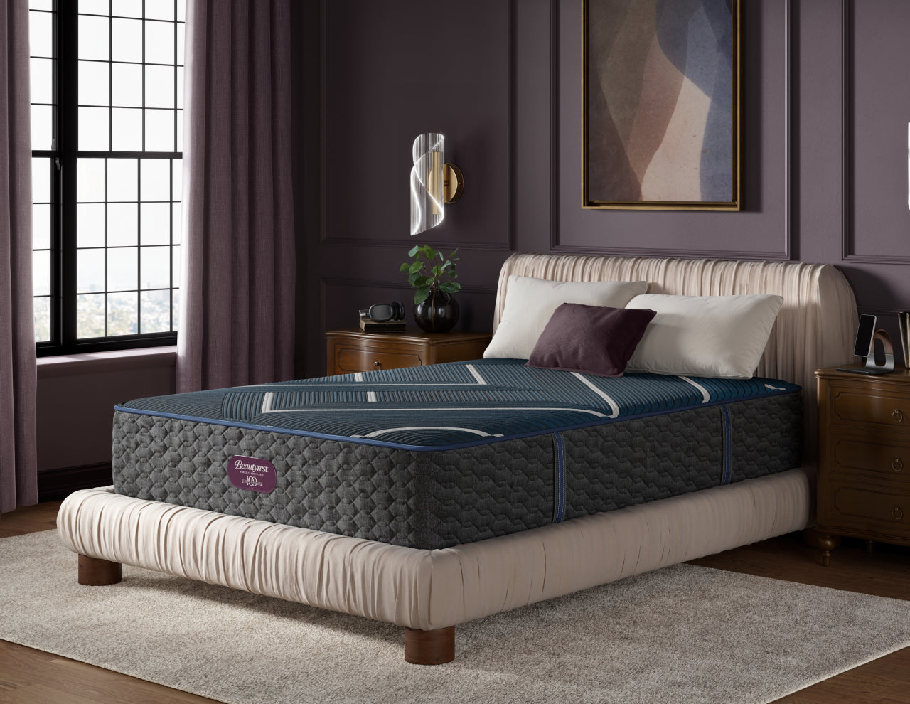 Beautyrest World Class Quilted Hybrid Level 4 mattress with 3 pillows on top of it sitting on a beige bed frame