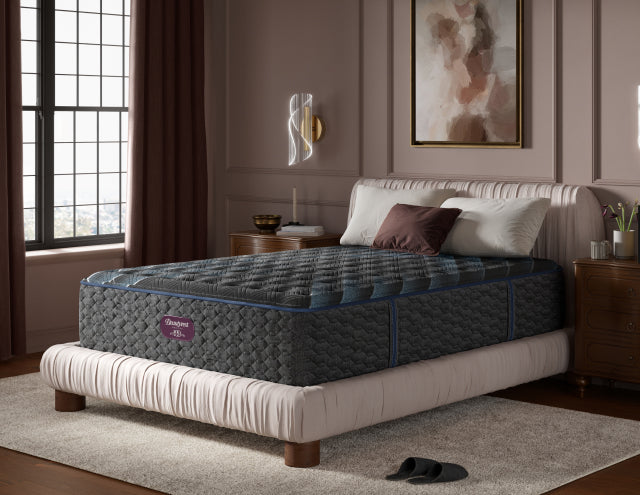 Beautyrest World Class Quilted Level 4 mattress with 3 pillows on top of it sitting on a beige bed frame