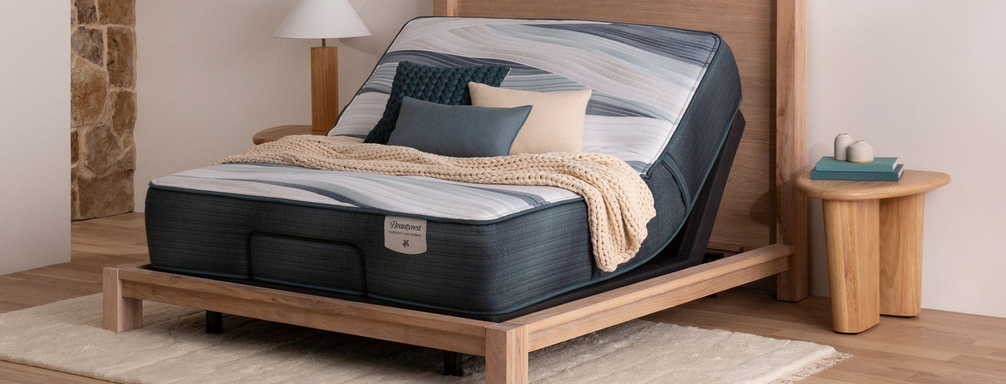 Beautyrest mattress sitting in a light brown wood bed frame on an adjustable base