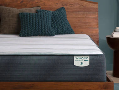 A Beautyrest Harmony Hybrid mattress with a smooth white memory foam top on a wooden bed frame, designed for support, motion isolation, and a cradled, body-hugging feel.