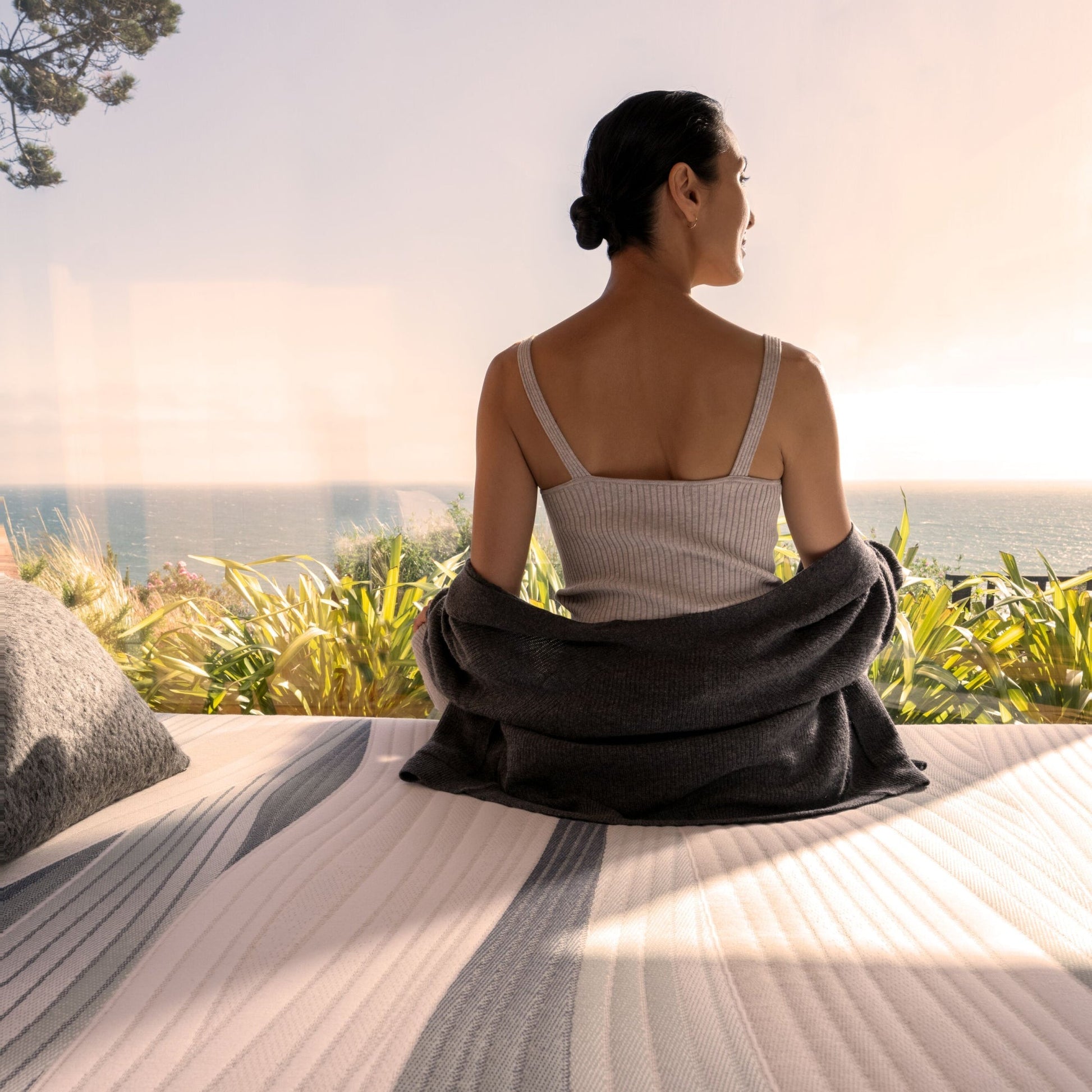 Woman looking out the window, sitting on the Beautyrest Harmony Lux Hybrid mattress || series: Exceptional Seabrook Island